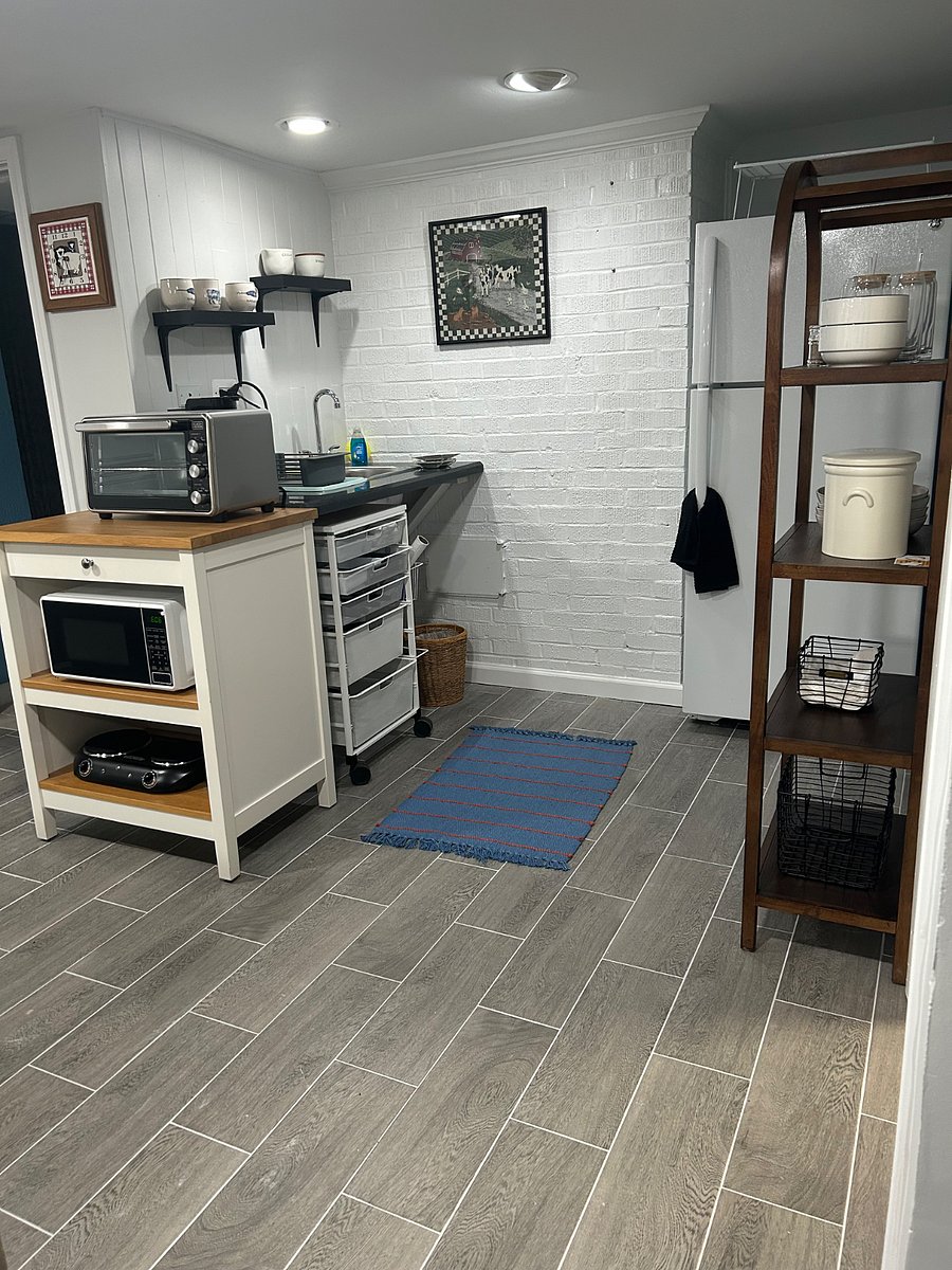Kitchenette with full-size refrigerator, microwave, toaster/air fryer, coffee maker, hot plate, cups, glasses, plates, and*** cutlery/utensils.