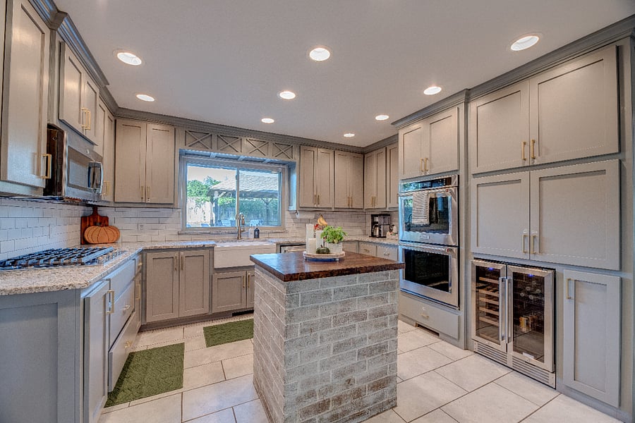 Modern kitchen with ample counter space, full cookware, and stainless appliances.