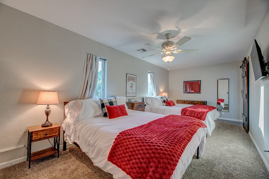 Upstairs bedroom with two queen beds, 40" smart tv, and large walk- in closet with plenty of storage space. 