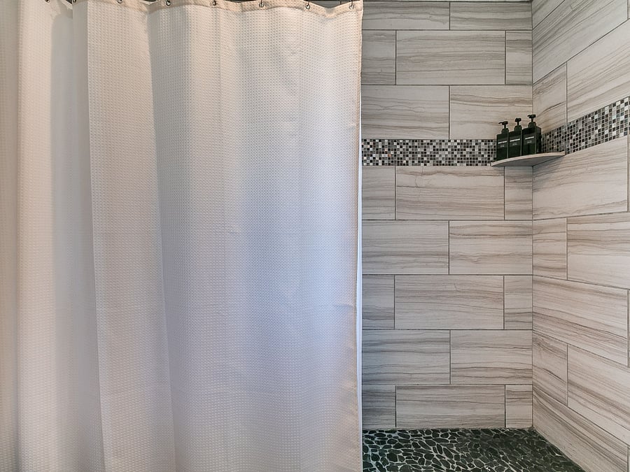 Spacious walk-in shower with modern tile and great water pressure.