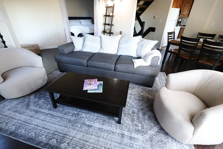 Living room with staircase in background of photo.