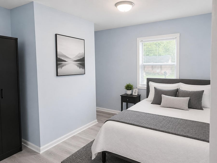 Comfortable bedroom with a full bed, nightstand, and wardrobe, plus a window with blinds and easy-care flooring.