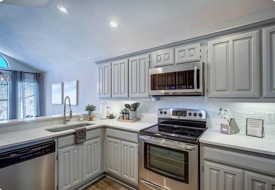 Kitchen with stainless appliances, quartz countertops, and a breakfast bar.