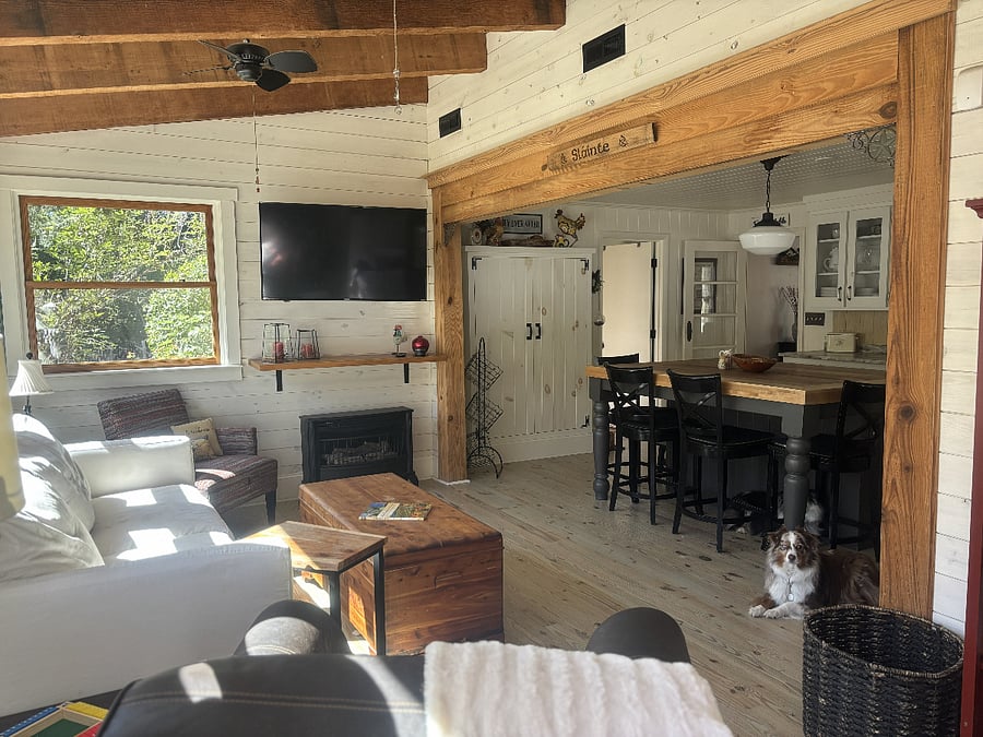 The family room offers cozy seating, large windows to the backyard, a smart TV, and a gas fire stove to add ambience.