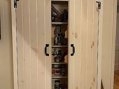 In the kitchen there is another pantry space for canned goods, bottles, and boxes.