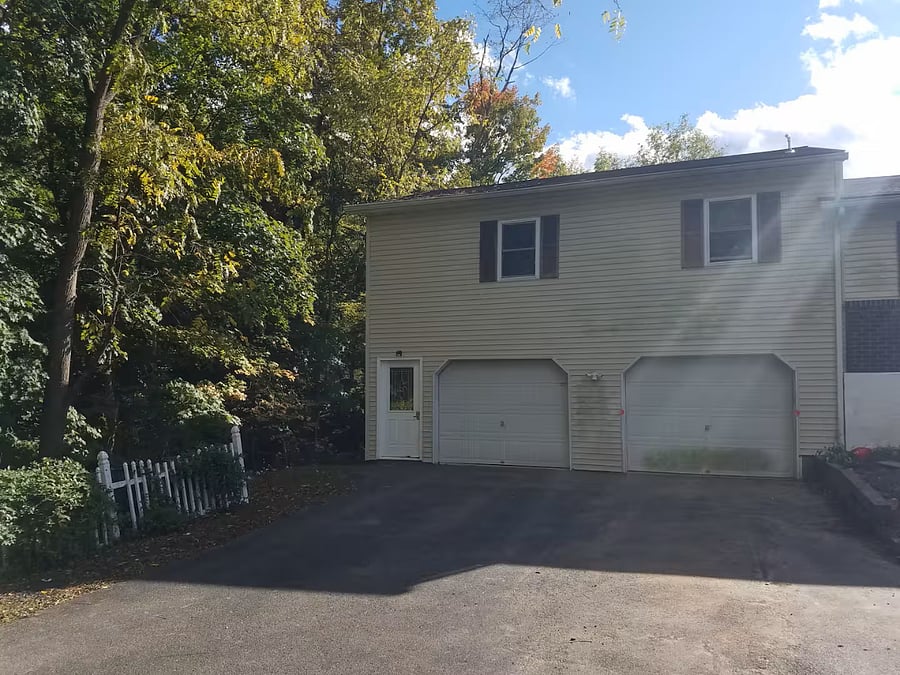 Apartment is above the garage with the entrance on the left side of the garage doors.