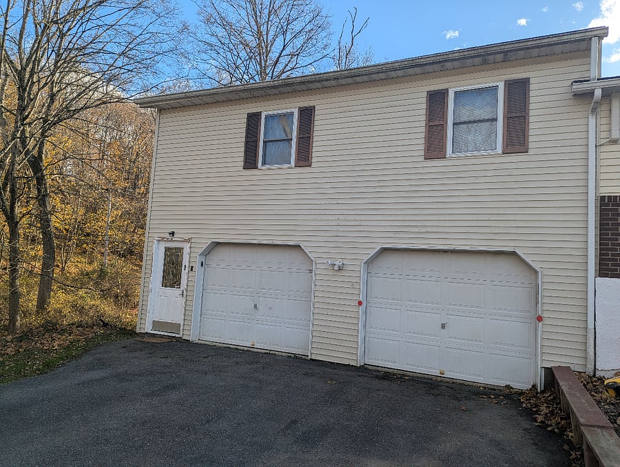 Apartment is above the garage with the entrance on the left side of the garage doors.