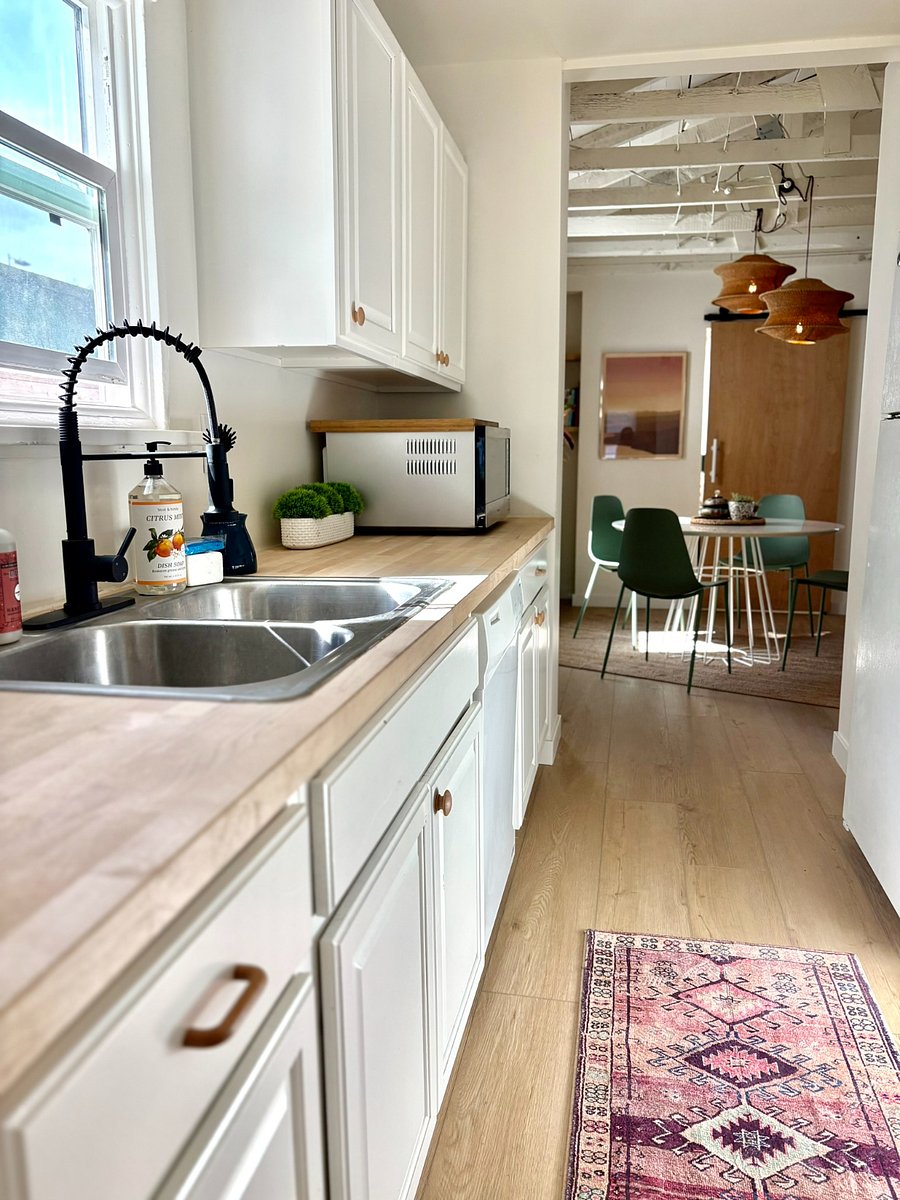 The kitchen is outfitted with birch butcher-block counters, stainless appliances (oven, cooktop, air fryer, coffee makers, dishwasher, and disposal), generous storage, and every essential item you need to cook, brew, and settle in with ease.