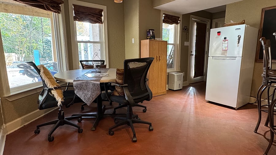 Private Dining nook with views of the pool and yard; main entrance to apartment and full sized refrigerator. 