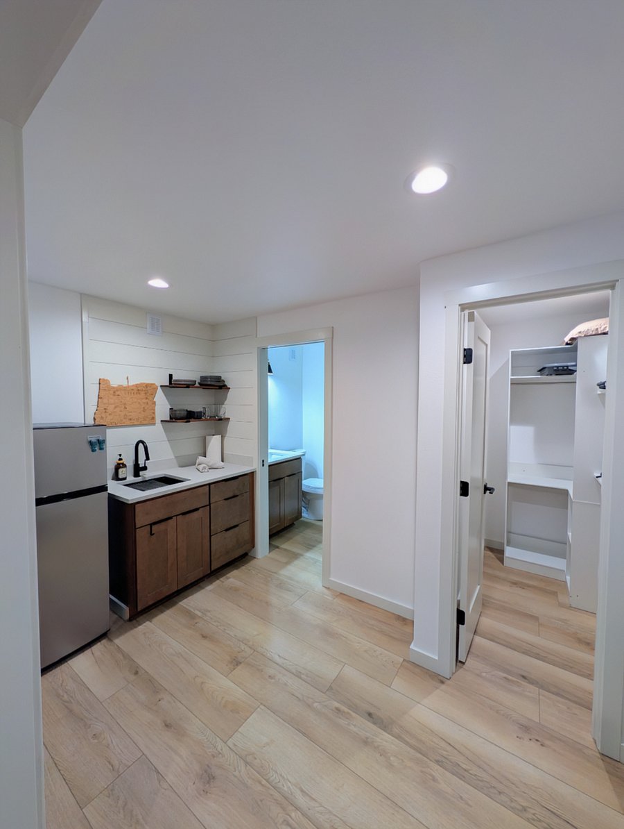 Kitchenette with fridge, tableware, cookware, electric induction cooktop.
