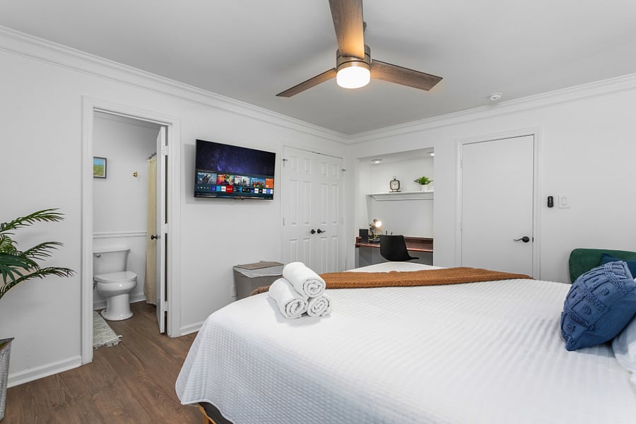 Bedroom 1: Private main-level primary suite featuring a King size bed, workspace, Smart TV, Walk-in Closet, full in-suite bathroom.