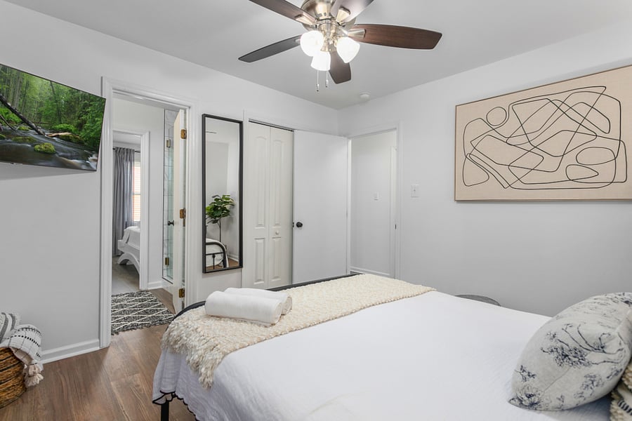 Bedroom 2: featuring a queen size bed, smart TV, full body mirror, closet space, and connecting door to the shared full bath.