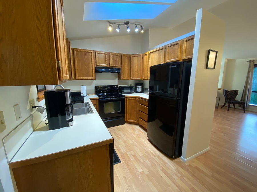 Kitchen has two skylights and is equipped with full fridge/freezer and range, dishwasher, coffee maker, microwave, toaster and air fryer. Place settings for 4.