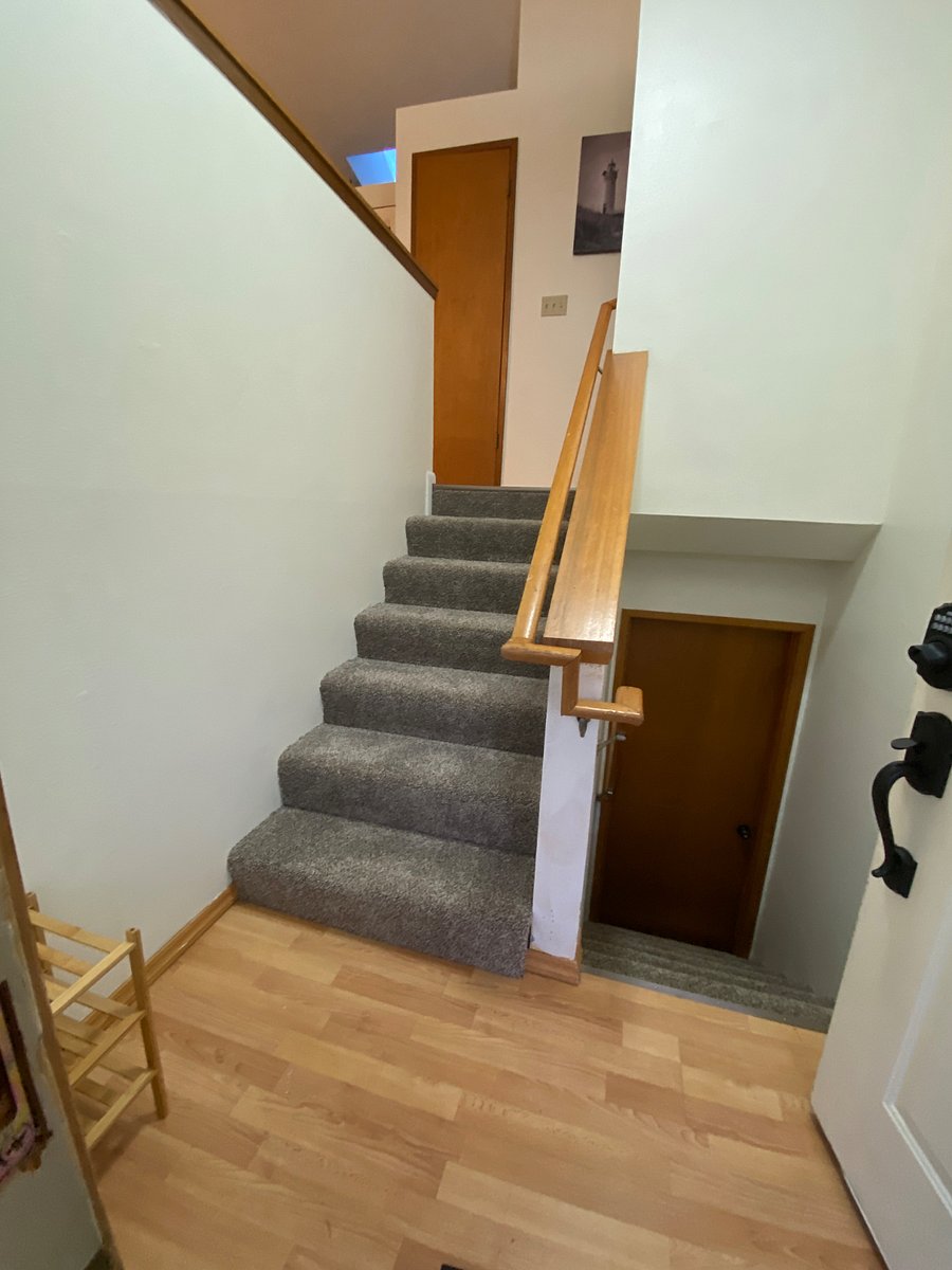 Split-level entry. Stairs on left go the upstairs apartment. Stairs to right go down to downstairs apartment and laundry in garage. The downstairs apartment won't be rented until remodeling done in 2026. The downstairs unit will have a separate entry and will not use these stairs. There will be a lock at the bottom of the stairs.