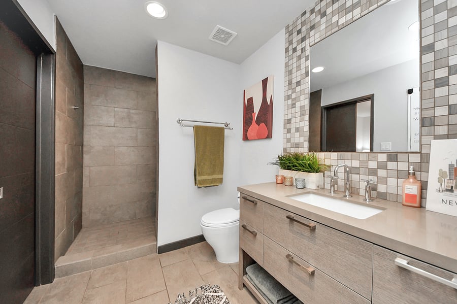 Pristine second full bathroom perfect for group travel and families! Features a modern custom vanity, chic tile backsplash, and ample open storage. Keep your Houston vacation stress-free with multiple full baths.