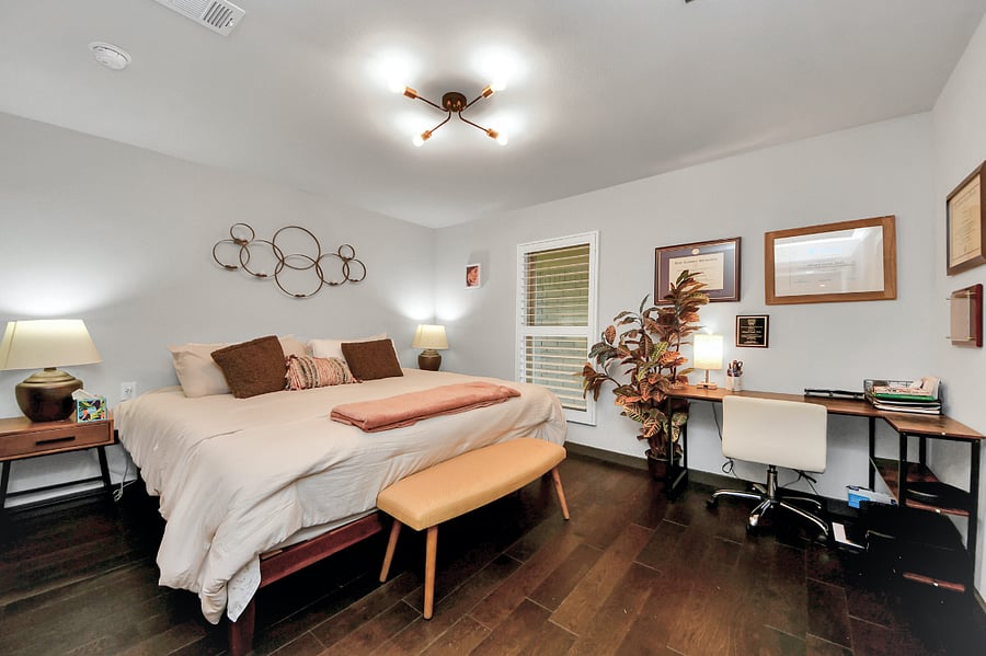 Rest easy in this beautifully styled space. Features crisp hotel-quality linens, minimalist decor, symmetrical nightstands with reading lamps, and natural light.