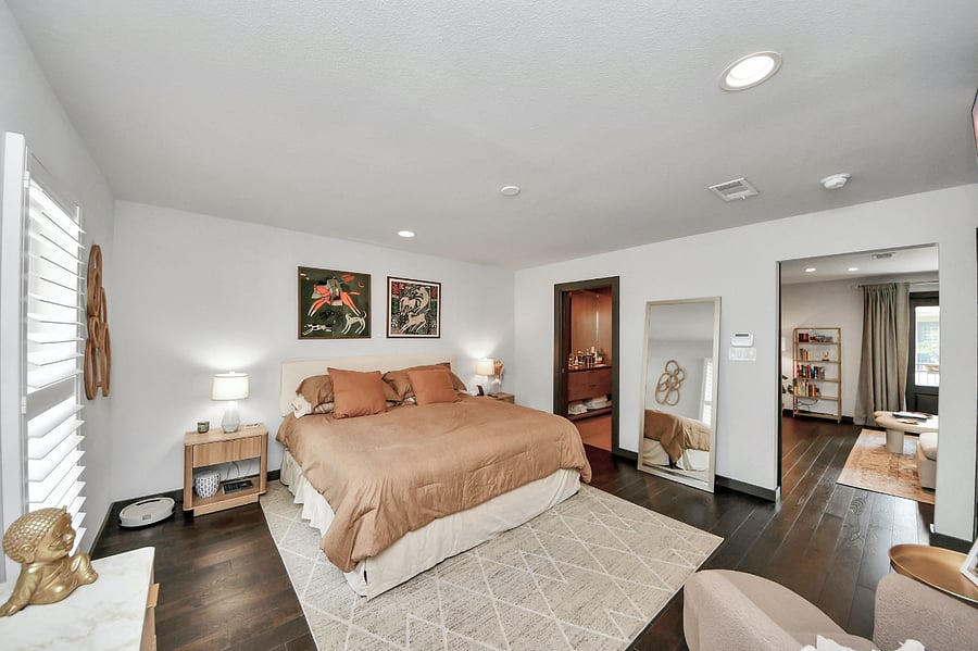 Admire the spacious layout and curated details from across the room. Highlights include the large full-length standing mirror and sleek mid-century inspired dresser.