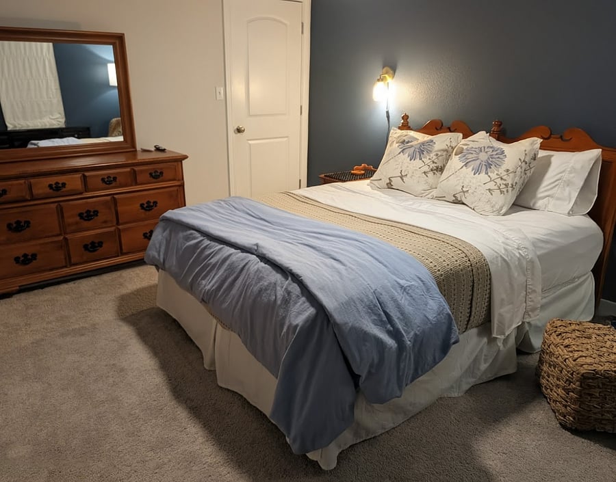 Queen bedroom set with dresser and nightstand and 50" wall mounted smart TV.