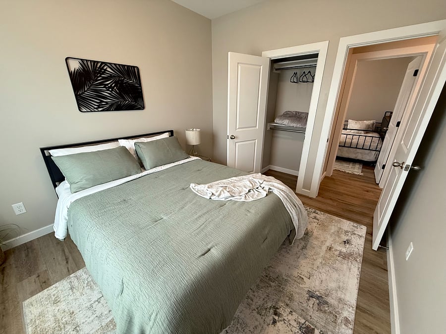 Cozy second bedroom featuring a nice queen bed with comfortable mattress, closet with plenty of hanging space and bedside table with a lamp. Extra blanket provided in the closet for those colder nights. Super quiet and perfect for a good nights sleep.