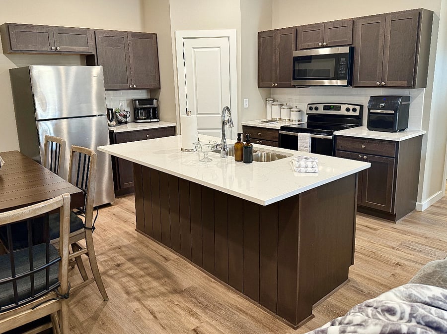 It features beautiful quartz countertops, a large island with bar seating for quick meals, stainless steel appliances, electric stove/oven, microwave, and dishwasher), Keurig and traditional coffee maker, air fryer, blender, all pots/pans, cooking utensils, knives, cutting boards, dishes, glasses, mugs, and silverware for 8 or more. We also provide coffee pods, dish soap, sponges, paper towels, and trash bags!