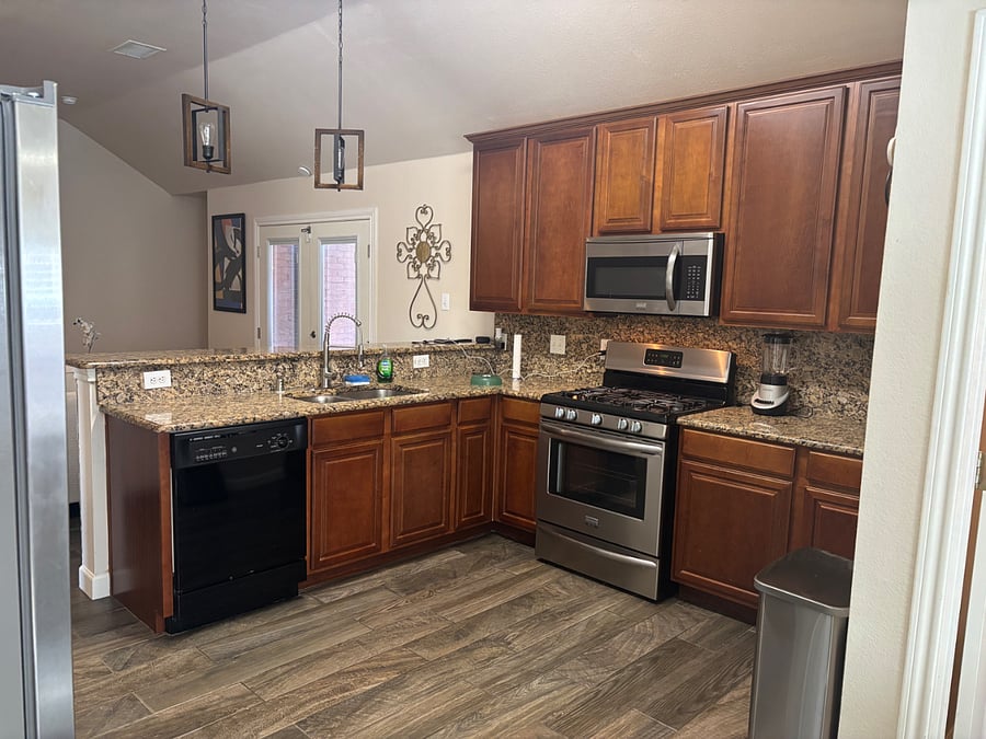 Kitchen with stove, dishwasher, full size refrigerator and microwave 