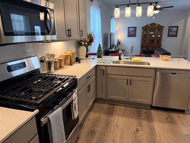 Fully equip shared kitchen area with stainless steel appliances, quartz counter top, subway tile backsplash, and a laundry room by the refrigerator. 