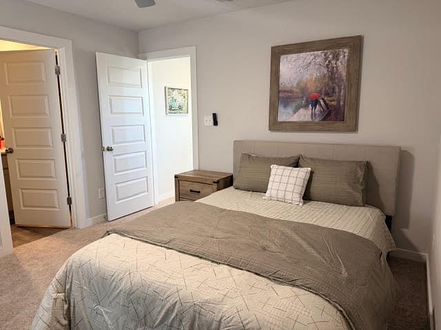 Bedroom with ensuite private, full bathroom or a 2nd primary bedroom fully furnished with ceiling fan with lights, 2" faux blinds and window coverings, carpeted bedroom.