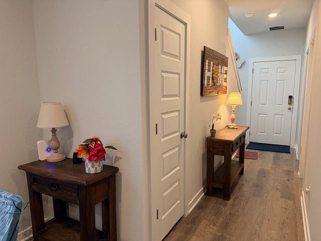 1st Floor hallway to front door, 1 bedroom by the entry, 1 full bathroom next to the bedroom on the hallway, a storage closet by the stairs, hallway leads to the dining area, kitchen, living room, side door to the covered patio in the private yard.