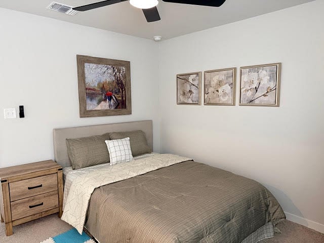 Bedroom with ensuite private, full bathroom or a 2nd primary bedroom fully furnished with ceiling fan with lights, 2" faux blinds and window coverings, carpeted bedroom.