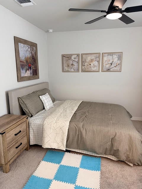 Bedroom with ensuite private, full bathroom or a 2nd primary bedroom fully furnished with ceiling fan with lights, 2" faux blinds and window coverings, carpeted bedroom.