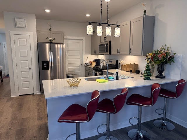 Kitchen area with island breakfast bar, and dining area. The door next to the fridge is the shared laundry room. 