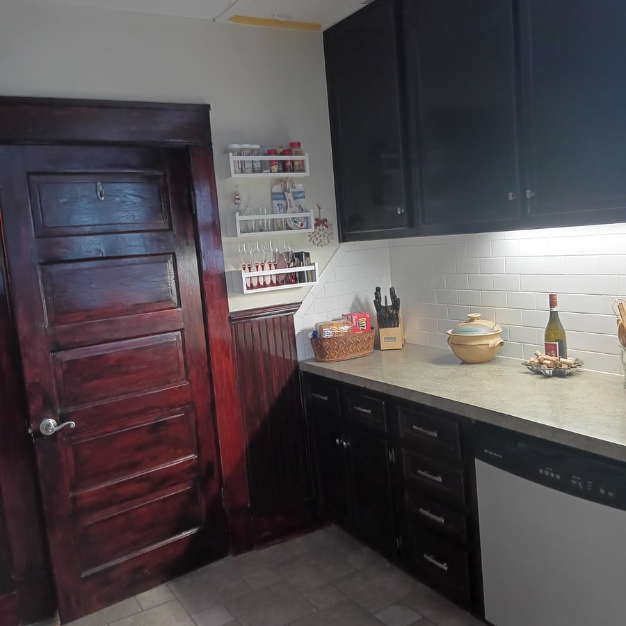 Original door and woodwork. Ample top and bottom cabinetry for storage (glasses, plates, silverware, linens...). Wall-mounted racks hold spices and more.