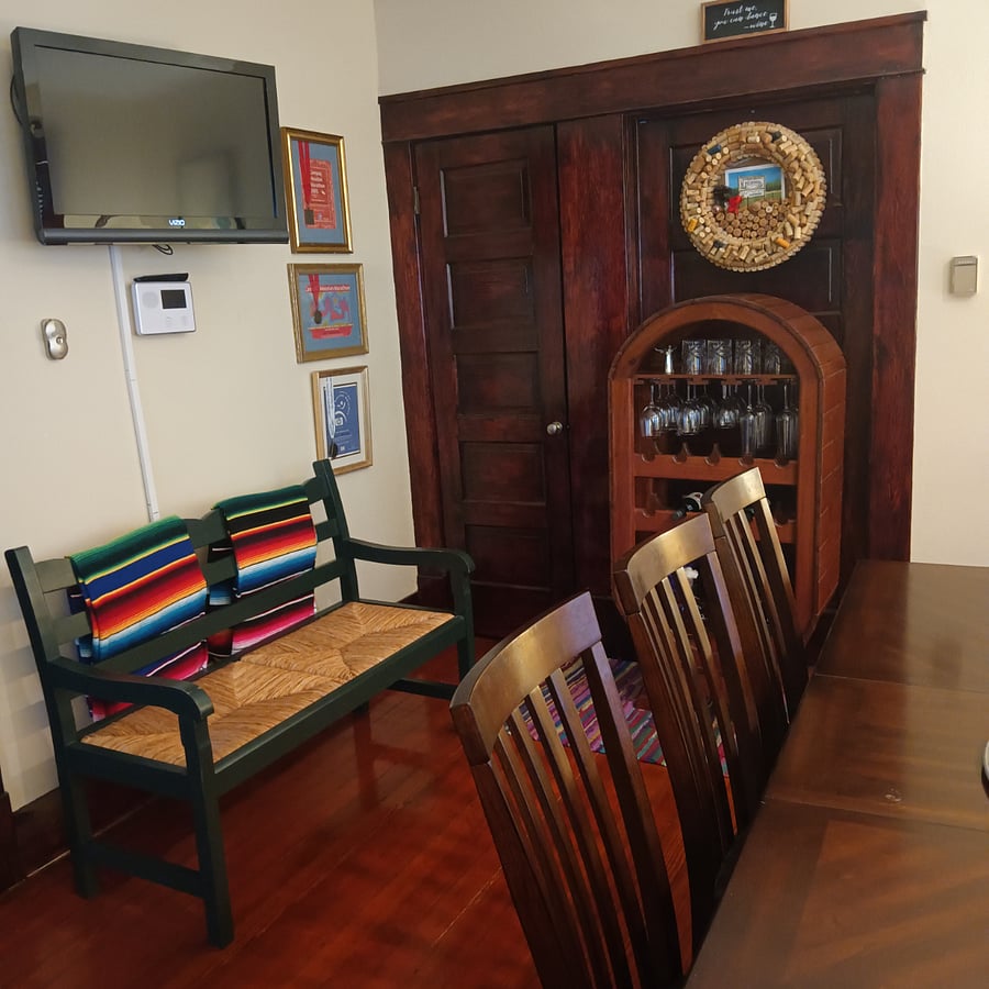 Crafted wood cabinet for wine bottles and wine glasses. This room has a closet for clothes. Bench provides more seating!