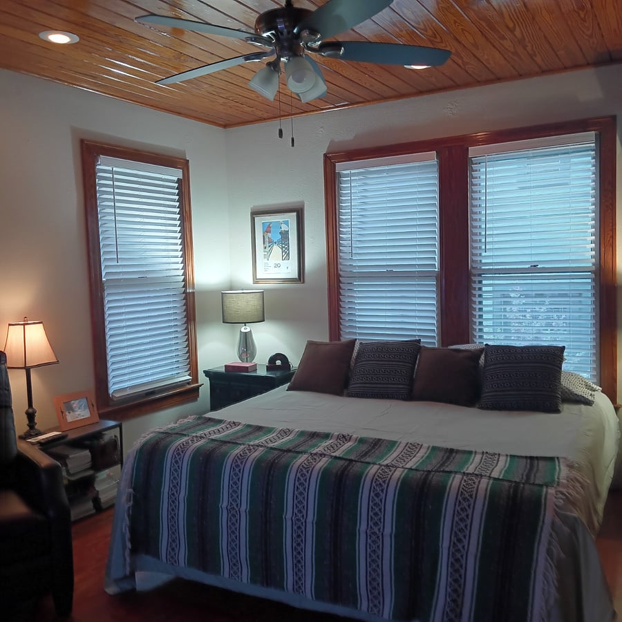 Small bookshelf next to comfortable recliner. This room has a ceiling fan with remote control and recessed dimmable lighting.