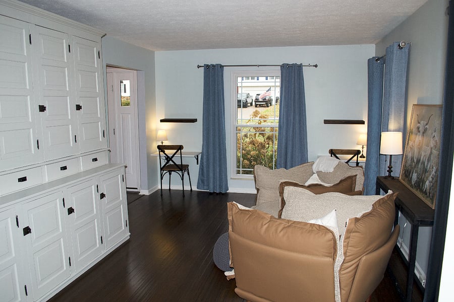 The formal living room is setup with two cozy chairs and two small desks. There's also a large storage cabinet. This room is perfect for a cozy afternoon reading.