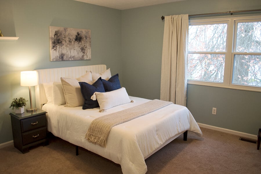 The first bedroom upstairs features a queen bed, nightstand, and large dresser. There's also a full closet. This bedroom overlooks the backyard with a great view of the massive oak trees.