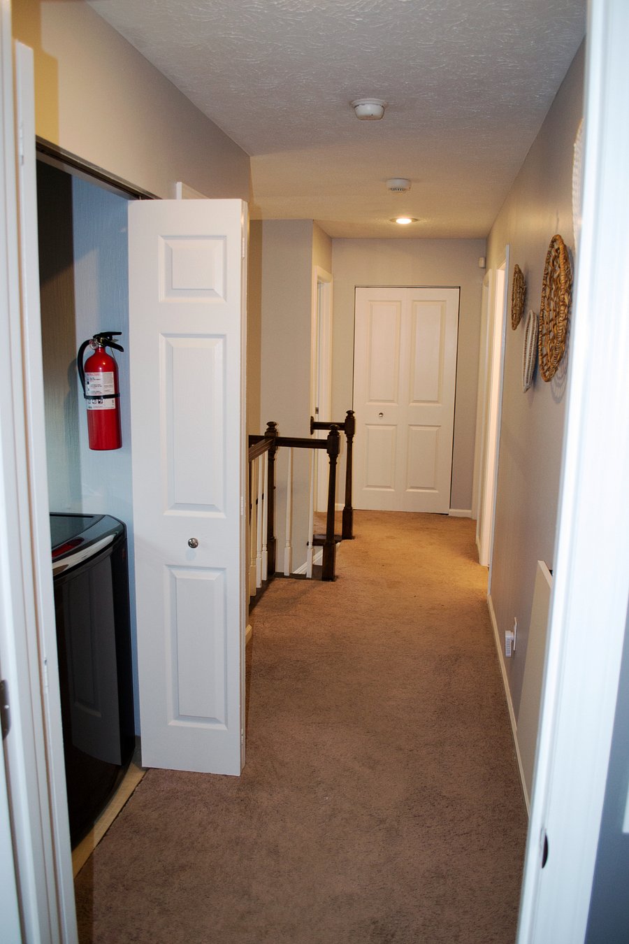 The upstairs hallway is bright and serves as a great space to complete your laundry task.