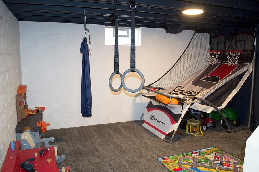 The other side of the lower level has toys and activities. Both sides are carpeted and well lit.