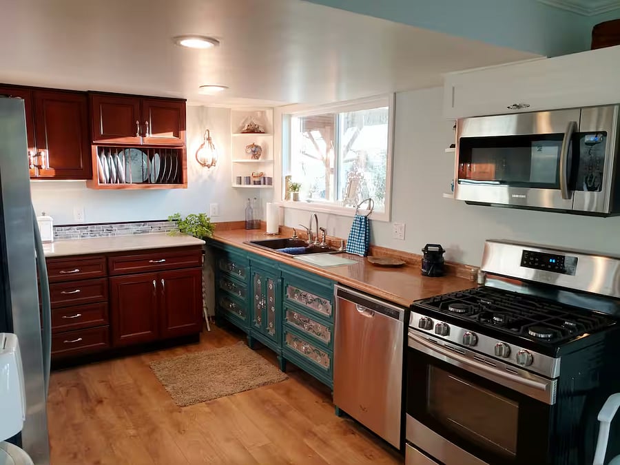 Right side of kitchen: stove, microwave, double sink, window with peek-a-boo water view.