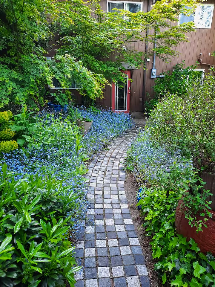 The path to your apartment door with gardens on both sides of the path.