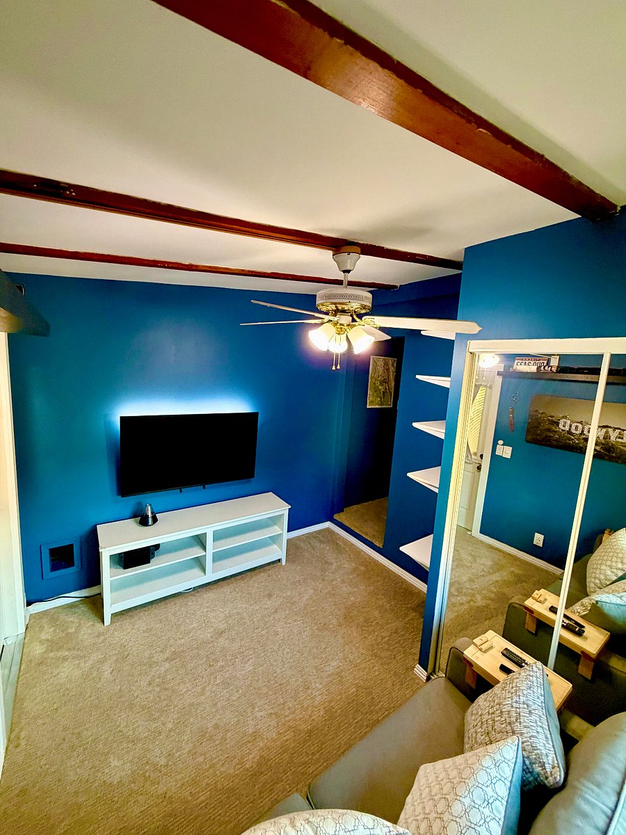 Smart entertainment setup with a mounted flatscreen TV, Apple TV, and Hue smart lighting you can customize to match your mood.