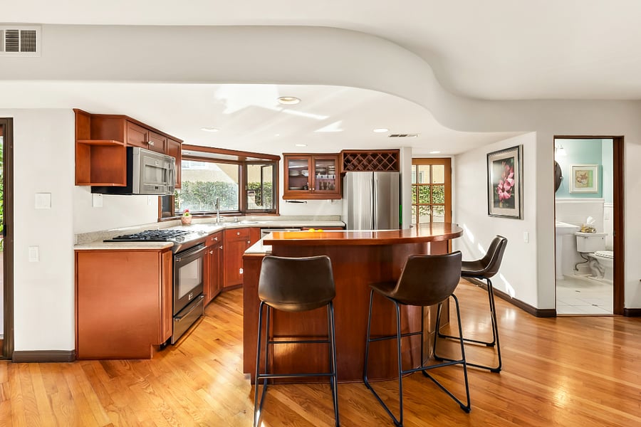 Fully equipped kitchen with large quartz center island, stainless appliances, bar seating