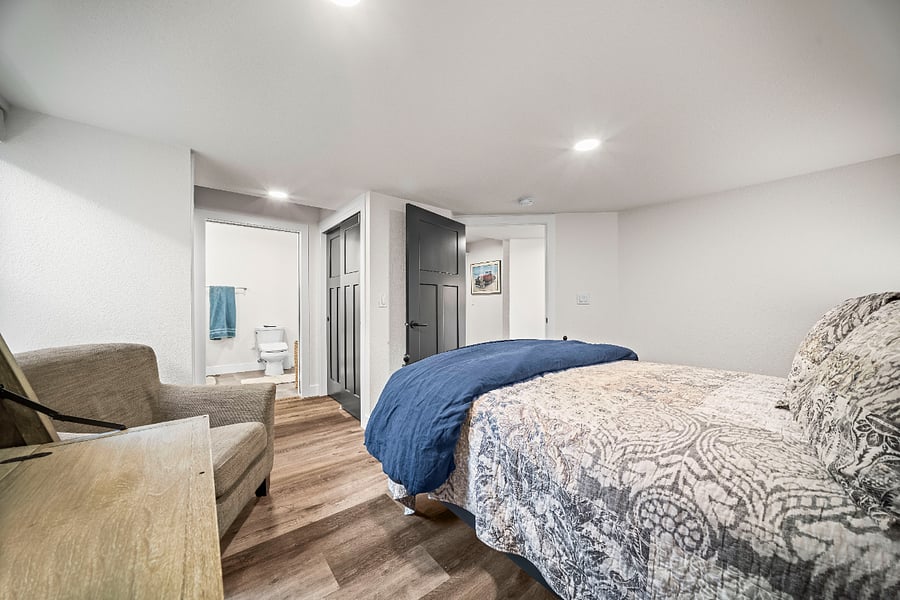 Bedroom with king bed and a clear, private layout leading to the bathroom and laundry area.