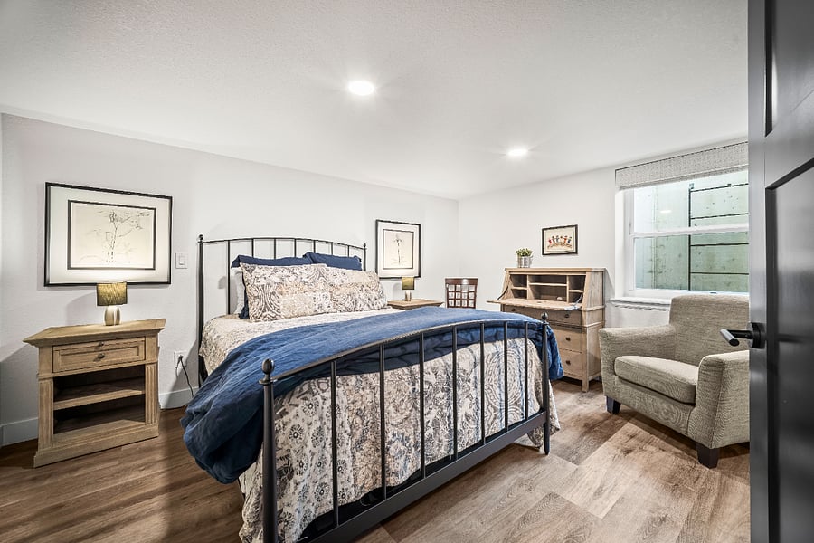 Spacious bedroom with a comfortable king bed, cozy seating area, and plenty of natural light.