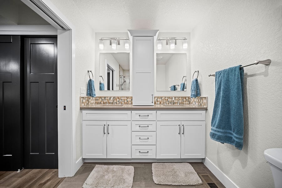 Large double-sink vanity with plenty of counter space and bright, clean lighting.
