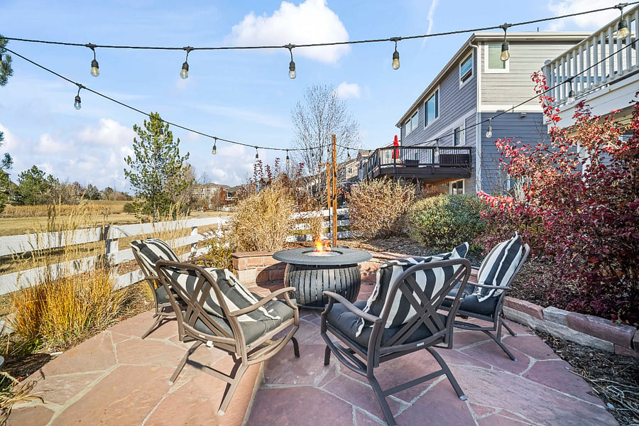 Fire pit patio area with beautiful landscaping and open greenbelt views.