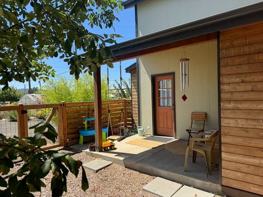 back porch with that opens onto a fenced yard shared with one other furnished finder house