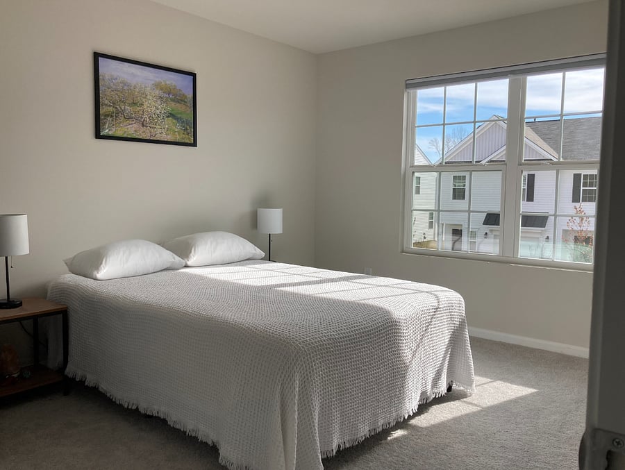 Bedroom B with brand new queen mattress, frame, and blackout cellular shade installed in the window.