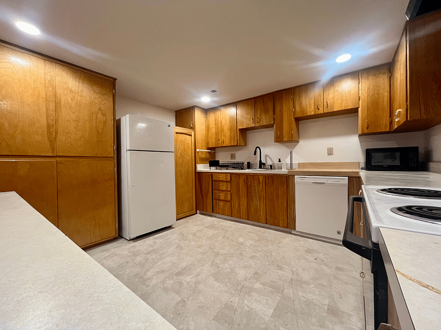 Kitchen from Bar/Countertop and VERY large pantry to the left of fridge. (please note the oven shown in this photo is no longer there, it had to be removed due to zoning/insurance purposes. An electric hotplate and countertop mini oven is avaialble)