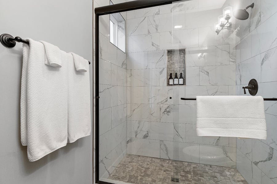 A modern ensuite bathroom featuring a spacious walk-in shower with marble tileperfect for a refreshing, spa-like start to your day.
